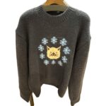 ネコと小花のデザインがほどされたネイビーのニットセーター