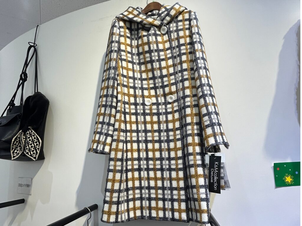 チェック柄のフード付きロングコート。