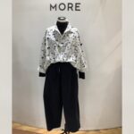 白地に黒の猫の顔が全面にプリントされたデザインシャツのスタイリング