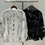 落書き風の英字プリントが施された綿素材の、ホワイトとブラックのドルマンシャツ。