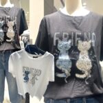 背面に後ろ姿の猫2匹がジルコンで装飾され、「FRIEND」の文字が胸元にデザインされたカジュアルTシャツ。