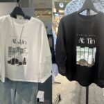 「At Tin」のロゴと、印象的な建築風景のフォトプリントが目を引くデザインTシャツ。
