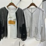 ブラックとグレーのメッシュ素材の丸首ジャケット。前面に大きなポケットが付いた軽やかな羽織りアイテム。